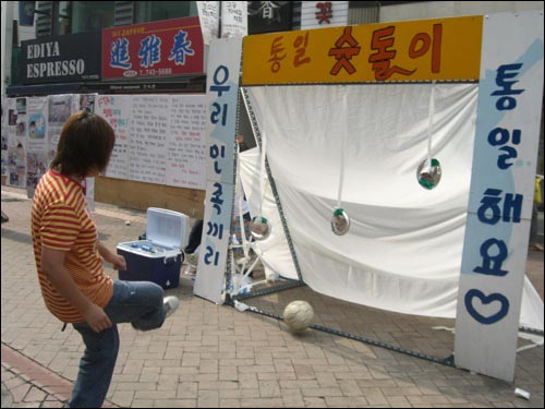 "뻥~ 우리나라 경제 말아먹으려는 ‘주인공’을 향해 축구공을 차주세요" 은박 접시에 축구공을 맞추면 시원한 캔커피가 제공된다. 